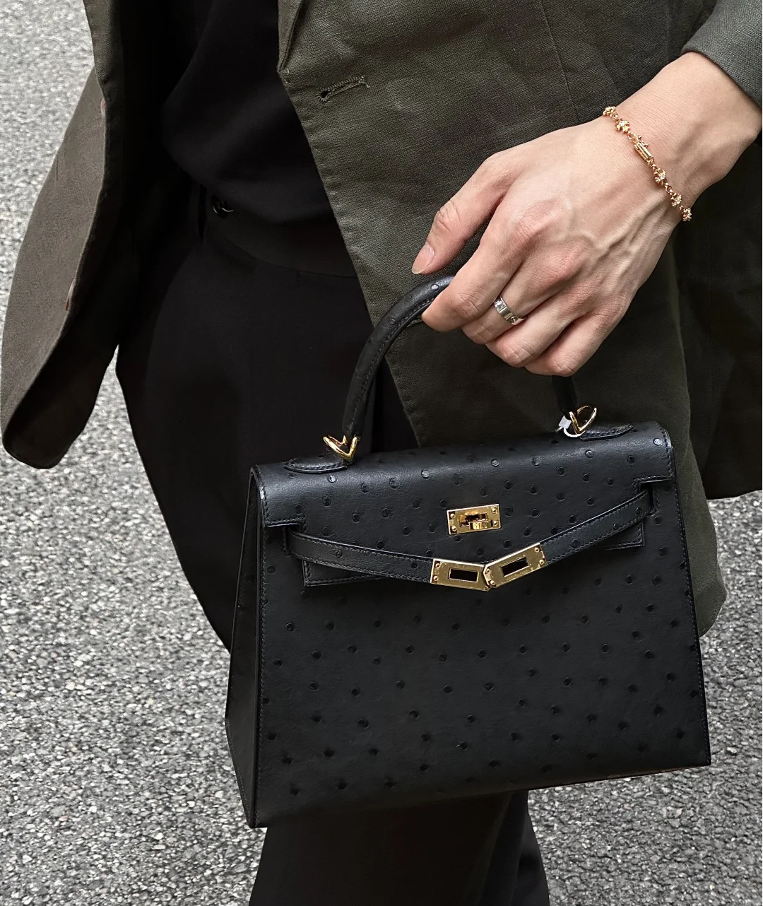 A black Hermes Kelly ostrich bag with gold hardware