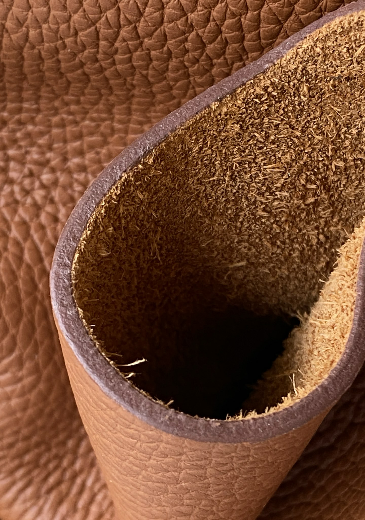 An extreme macro photograph focusing on the meticulous brown edge paint finishing on the rim of the Hermes Picotin bag