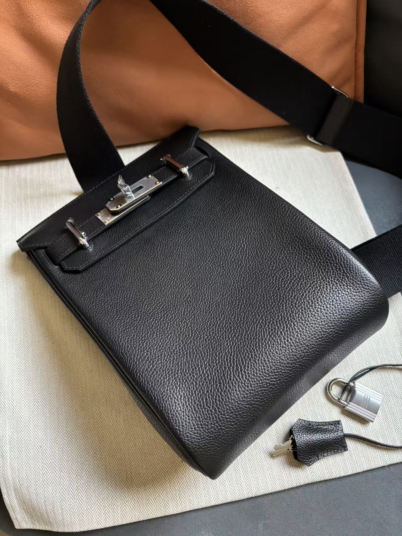 Angled shot of the HAC a Dos PM showcasing the minuscule printed grain and waxy texture of premium Black Barenia Faubourg calfskin.