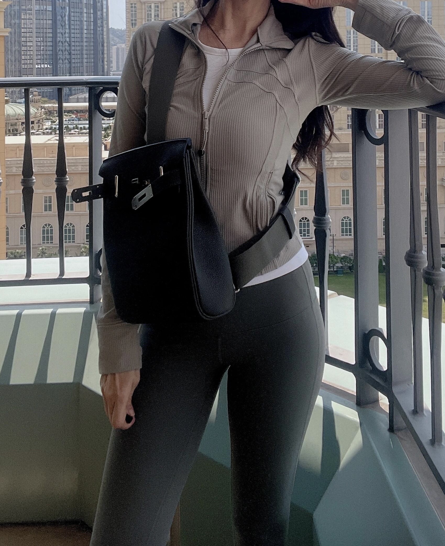 A buyer review photo showing the HAC a Dos in Black leather styled as a crossbody bag on a woman