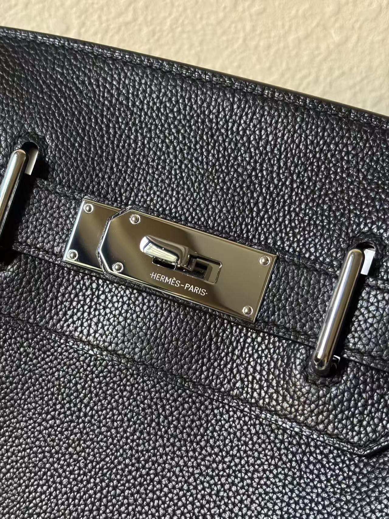 Macro shot of the palladium-plated hardware on a HAC a Dos PM, featuring the crisp "HERMÈS-PARIS" engraving and hand-finished pearling rivets.