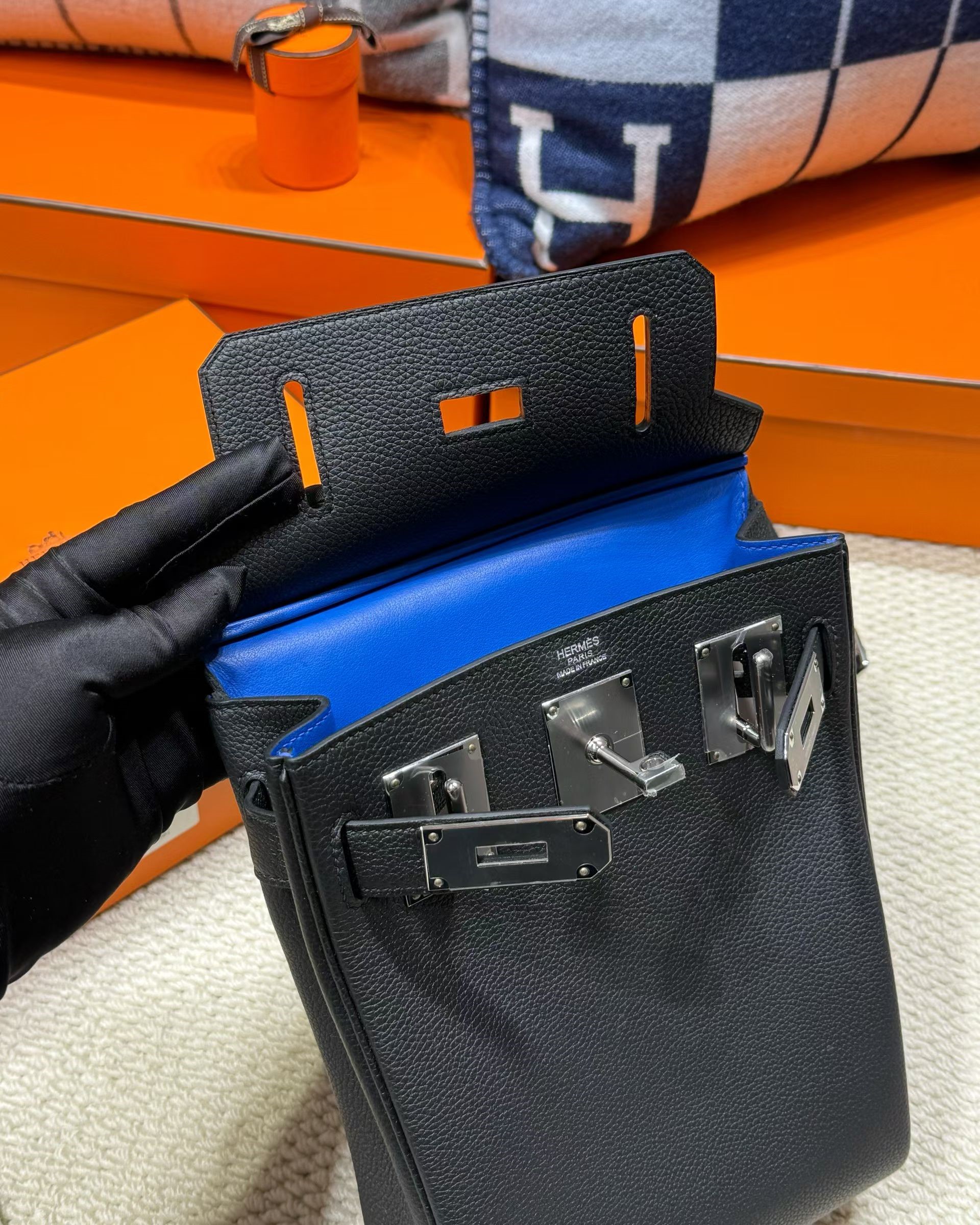 A striking view of a custom Togo Verso HAC a Dos PM in Black, revealing a brilliant, contrast Blue leather interior lining.